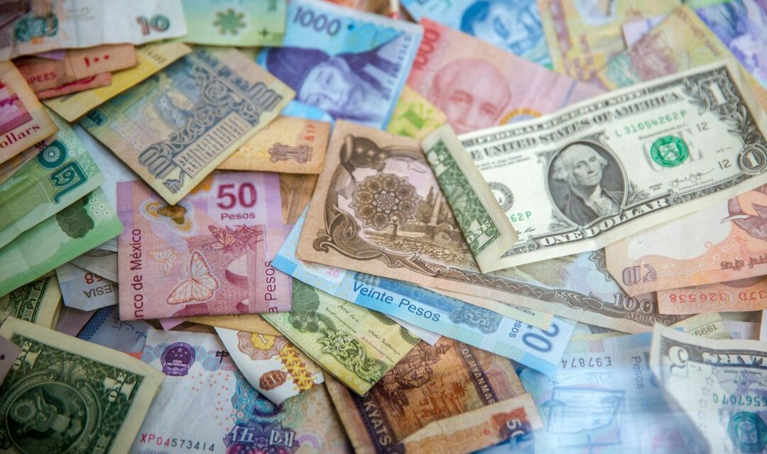 International banknotes spread on a table — naira exchange rate guide